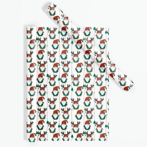 May include: White wrapping paper with a repeating pattern of gnomes wearing red hats and green outfits with reindeer antlers. The gnomes are holding red and white candy canes and are surrounded by small green trees and white snowflakes.