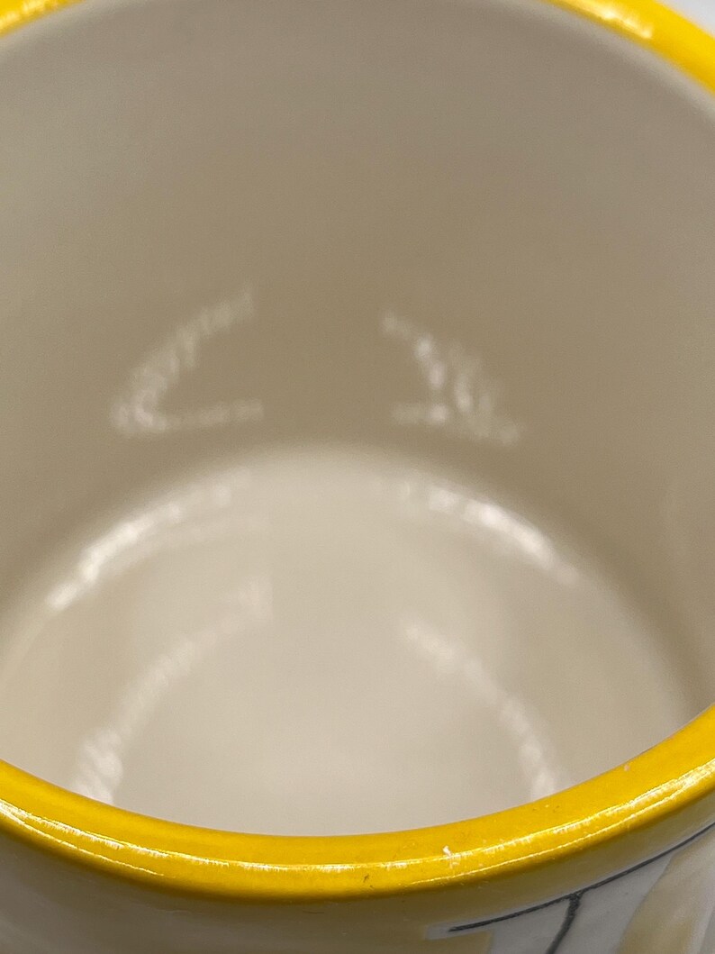 Puede incluir: Una taza de cer&aacute;mica con interior color crema y borde amarillo brillante. El interior tiene marcas sutiles de color claro. El dise&ntilde;o de la taza es simple y limpio, con un enfoque en el contraste de los colores.