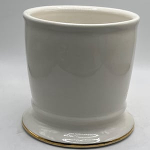 May include: White ceramic shaving mug with a gold rim. The mug has a wide base and a cylindrical shape.