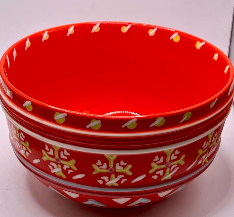 Puede incluir: Una taza de cer&aacute;mica blanca con asa negra y el texto "But First, Coffee" en negrita negra. La taza se encuentra sobre un fondo borroso, sugiriendo un ambiente acogedor.