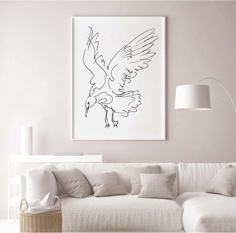 May include: A framed black and white line drawing of a seagull in flight. The artwork depicts the bird with outstretched wings and a downward gaze, set against a white background. The minimalist style adds a modern touch to the wall art.