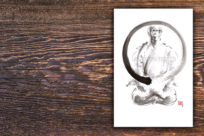 May include: Black and white ink drawing of a person in a seated meditation pose, framed by a large, incomplete circle. The artwork is on white paper, with a red stamp in the lower right corner. The background is a wooden surface.