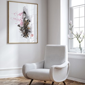 May include: Framed art print featuring a watercolor illustration of a samurai holding a sword, with cherry blossoms in pink and a red seal. The artwork is in a gold frame, displayed in a bright room with a white armchair.