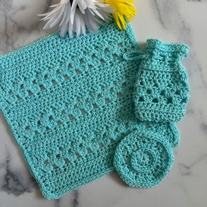 May include: A set of three crocheted items in a light blue color. The set includes a large square, a small round piece, and a small pouch.