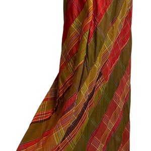 May include: A long, flowing skirt with a plaid pattern in shades of red, green, and yellow. The skirt has an elastic waistband and a relaxed fit.