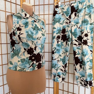 May include: A sleeveless blouse and pants set with a white background and a blue and brown floral pattern.