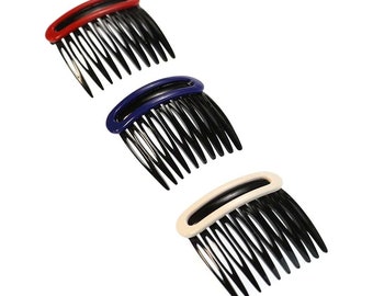 May include: Three hair combs with black teeth and colored plastic tops. The combs are red, blue, and cream.