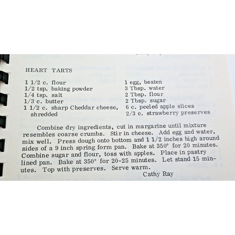 Op de afbeelding: Een gedrukte receptpagina met de titel HEART TARTS met zwarte tekst op een witte achtergrond. Het bevat ingredi&euml;nten zoals bloem, bakpoeder, zout, boter, Cheddar-kaas, ei, water, suiker, appelschijfjes en aardbeienjam, plus de instructies.
