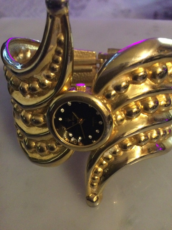 Oryx gold tone cuff bracelet quartz watch.