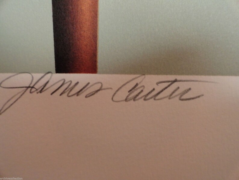 K&ouml;nnte beinhalten: Eine wei&szlig;e Karte mit der Unterschrift "James Carter" in schwarzer Tinte.