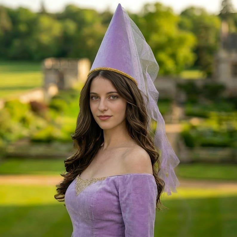 A woman wearing a purple off-the-shoulder dress and a purple cone-shaped hat stands in a garden setting.