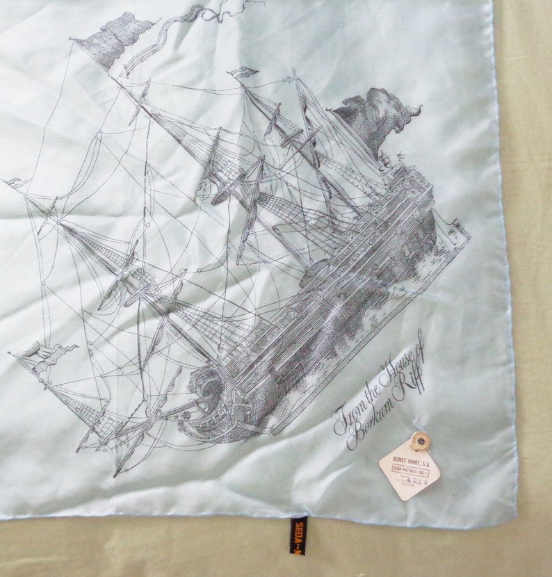 May include: A light blue silk scarf featuring a detailed black and white illustration of a sailing ship. The scarf has a tag that reads "From the House of Berkum Riff". The scarf is square and has a sewn edge.