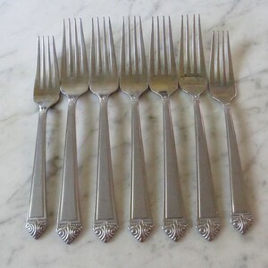Pode incluir: Oito garfos de prata com desenhos ornamentados na base do cabo.