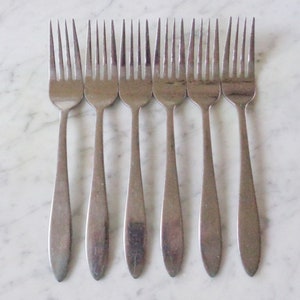Puede incluir: Juego de ocho tenedores de plata con un diseño simple y elegante. Los tenedores tienen un acabado liso y pulido y un mango ligeramente curvado.