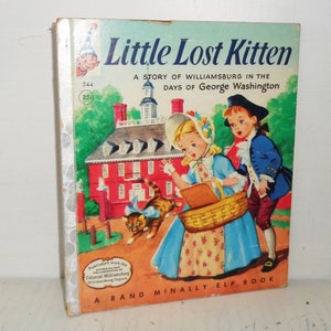 May include: A vintage children's book cover featuring a red brick building with a white steeple, a girl in a blue dress, a boy in a blue jacket, and a brown and white kitten. The book title is "Little Lost Kitten: A Story of Williamsburg in the Days of George Washington".