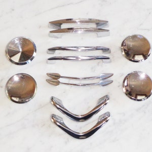 Puede incluir: Surtido de pomos y tiradores de armario cromados en varias formas y tamaños.