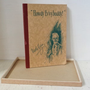 May include: A brown book with a red spine and the text "Howdy Evvybuddy!" on the front cover. The book has a green illustration of a man with a mustache and a cane. The text "Uncle Ezra" is written in cursive on the front cover.