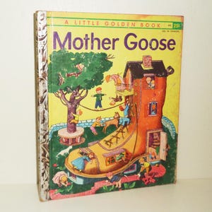 Puede incluir: Un pequeño libro dorado con una cubierta amarilla y el título "Mother Goose". La cubierta presenta una ilustración de un zapato gigante con una casa construida en su interior. Los niños juegan en el techo y alrededor del zapato.