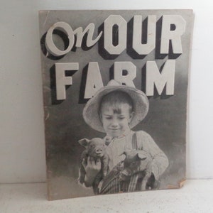 Peut inclure: Photographie en noir et blanc d'un jeune gar&ccedil;on portant un chapeau de paille et tenant deux porcelets. La photo est sur une couverture de livre avec le titre "On Our Farm" en grandes lettres audacieuses.