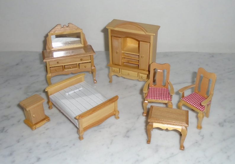 May include: A miniature dollhouse furniture set with a wooden bed, dresser with a mirror, armoire, two chairs, and a table. The chairs have red and white checkered cushions.