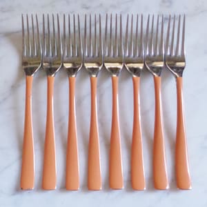 May include: Set of eight silver forks with peach-colored handles.