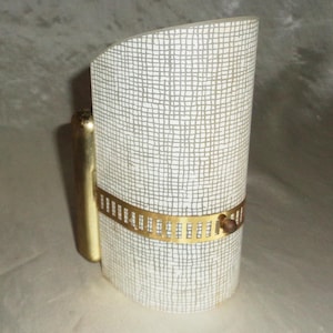 May include: A vintage wall sconce with a cylindrical shade featuring a white and gray grid pattern. The sconce has a gold-colored metal band and a gold-colored arm for mounting. The design is mid-century modern.