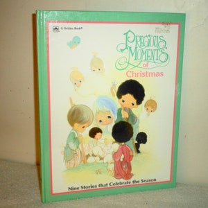 May include: A green book featuring an illustration of Precious Moments characters celebrating Christmas. The title reads "Precious Moments of Christmas" and the subtitle is "Nine Stories that Celebrate the Season".