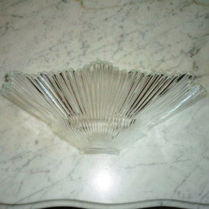 May include: A clear glass lampshade with a fan-shaped design. The shade is made of many thin, vertical glass pieces.