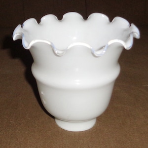 May include: White glass lampshade with a ruffled edge and a slightly iridescent finish.