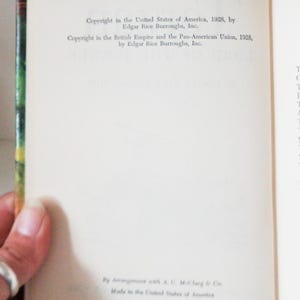 May include: A close-up of a book's copyright page, showing the copyright information for the book "Tarzan and the Jewels of Opar" by Edgar Rice Burroughs, Inc. The copyright dates are 1928 for the United States of America and the British Empire and the Pan-American Union.
