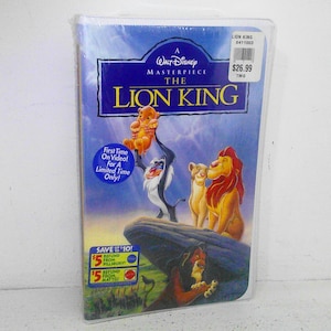 May include: A VHS tape of the Disney movie The Lion King. The cover features Simba, Mufasa, and Nala. The text on the cover reads "A Walt Disney Masterpiece The Lion King".