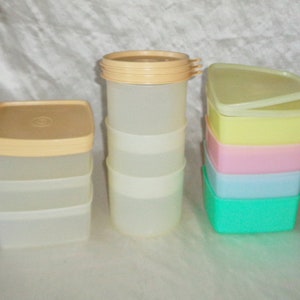 Puede incluir: Un juego de recipientes de almacenamiento de plástico transparente con tapas. Los recipientes están apilados en diferentes tamaños y colores, incluyendo amarillo, rosa, azul y verde.