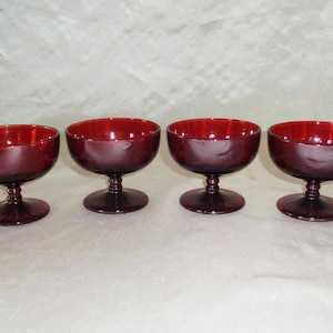 Puede incluir: Juego de cuatro platos de postre de vidrio rojo con base con tallo.