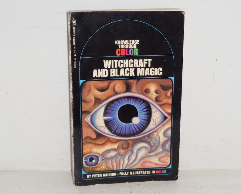May include: A book cover with a black background and a large, colourful eye illustration. The title is "Knowledge Through Colour: Witchcraft and Black Magic" by Peter Haining. The book is fully illustrated in colour.