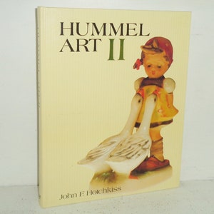 May include: A book titled "Hummel Art II" featuring a girl figurine with a red hat and yellow dress holding two white geese. The book cover is yellow with a textured background.
