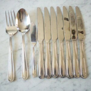 May include: A set of silverware, including a fork, spoon, and butter knife, all with a silver finish and a rounded handle.