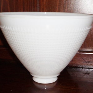 May include: White glass lampshade with a textured, waffle-like pattern. The shade is cone-shaped and has a smooth, rounded bottom.