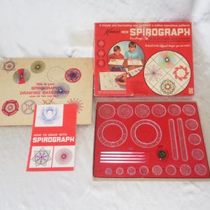 May include: A red box with the words "NEW SPIROGRAPH" on the front. The box contains a Spirograph drawing set with a variety of plastic gears and rulers. The box also includes a drawing board with instructions on how to use the Spirograph.