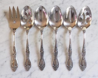 Könnte beinhalten: Sechsteiliges Besteckset aus Silber, bestehend aus einer Serviergabel und fünf Schöpflöffeln. Die Löffel haben verzierte Griffe mit einem floralen Muster.