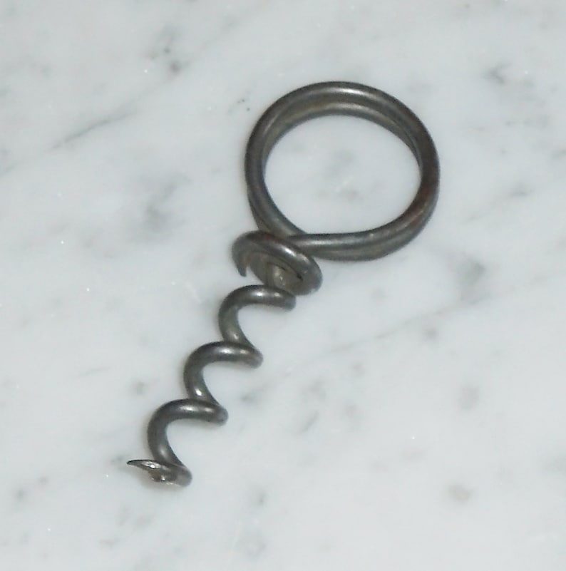 May include: A silver metal corkscrew with a coiled screw and a ring handle.
