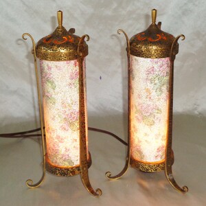 May include: A pair of antique gold table lamps with ornate metal bases and floral patterned glass shades.