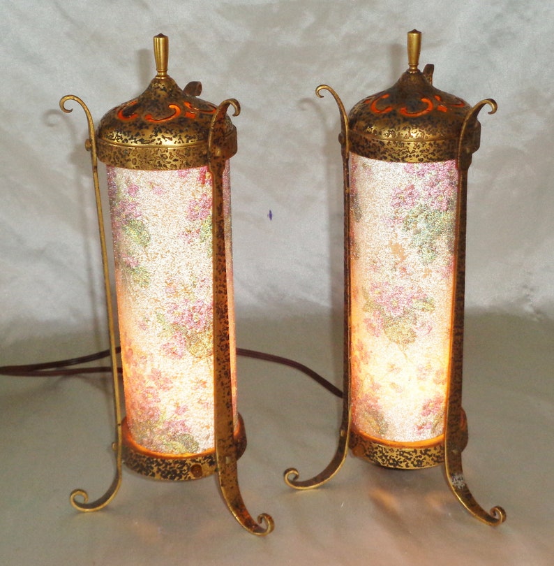 May include: A pair of antique gold table lamps with ornate metal bases and floral patterned glass shades.