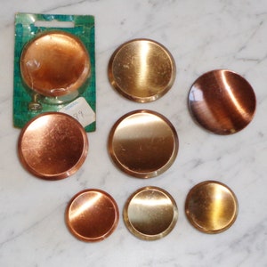 Peut inclure: Ensemble de huit couvercles ronds en métal pour brûleurs de cuisinière. Les couvercles sont de deux couleurs : cuivre et or. Les couvercles sont légèrement bombés et ont une finition brillante.