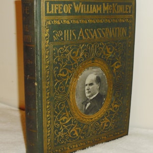 May include: A green hardcover book with gold lettering and a portrait of William McKinley on the front cover. The title reads "Life of William McKinley and His Assassination".