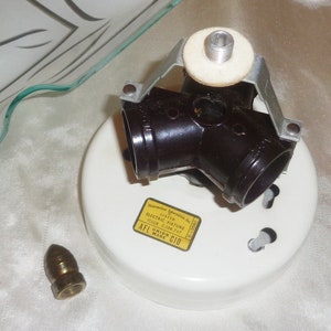 May include: A white ceiling fixture with three brown electrical outlets. The fixture is labeled "Listed Electric Fixture Issue C-109 747 AFL-CIO Union Made".
