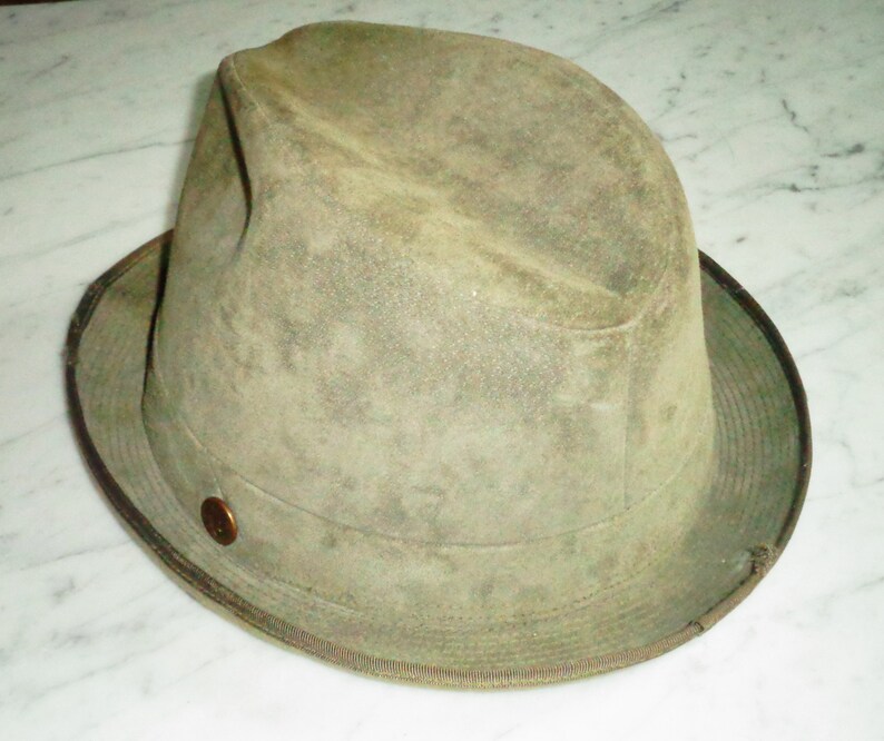 May include: A green felt fedora hat with a brown band and a brass button.