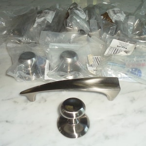 Puede incluir: Un juego de herrajes para puertas de níquel cepillado, que incluye una manija de palanca, una perilla redonda y dos perillas más pequeñas. El herraje está empaquetado en bolsas de plástico transparentes.