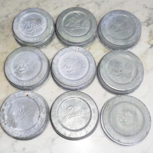 May include: Ten silver metal jar lids with the word "Ball" embossed on each lid.