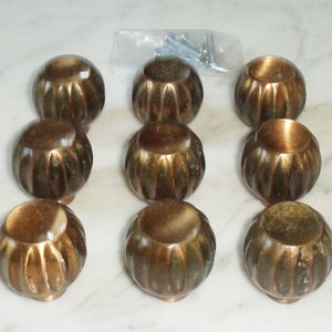 Puede incluir: Diez pomos redondos de latón para armario con diseño acanalado. Los pomos tienen un acabado ligeramente envejecido, de estilo antiguo.