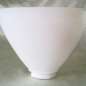May include: A white, cone-shaped lampshade with a textured, dotted pattern. The lampshade has a wide opening and tapers down to a small, circular base. The shade is made of a translucent material.